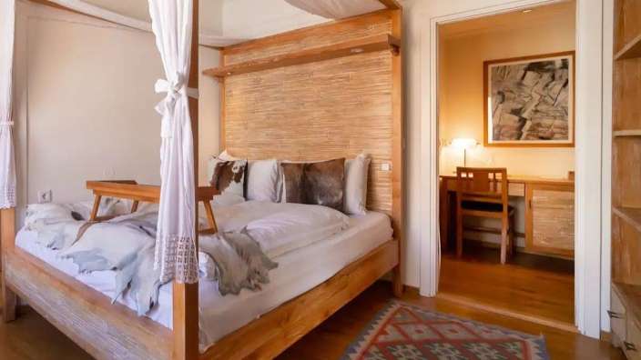 Ein Schlafzimmer mit einem Himmelbett und einem Schreibtisch