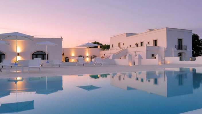 Ein weißes Gebäude mit einem großen Pool davor