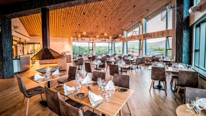 Ein großes Esszimmer mit vielen Tischen und Stühlen