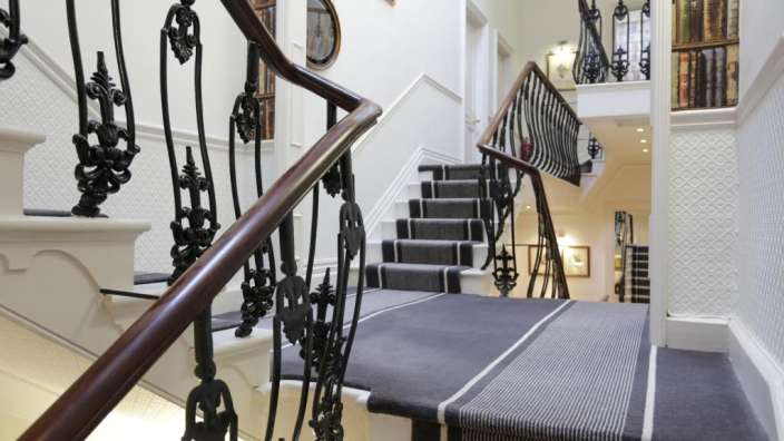 Eine Treppe mit einem schwarz-weiß gestreiften Teppich