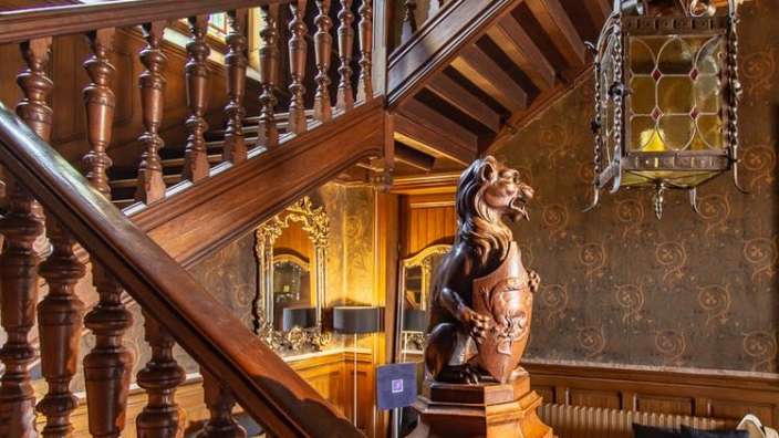 Eine Holztreppe mit einer Statue eines Löwen darauf