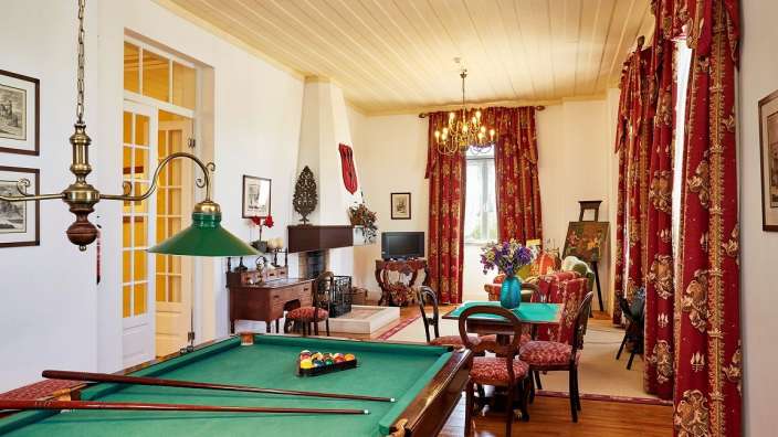 Ein Wohnzimmer mit einem Billardtisch und einem Kamin