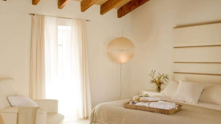 Ein weißes Schlafzimmer mit einem Bett und einem Stuhl