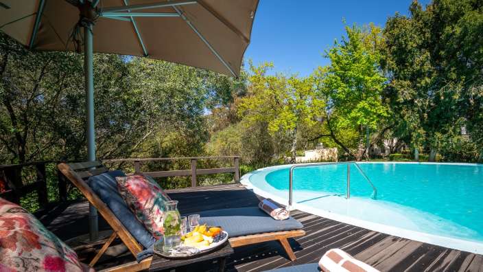 Liegestühle auf einem Deck neben einem Swimmingpool