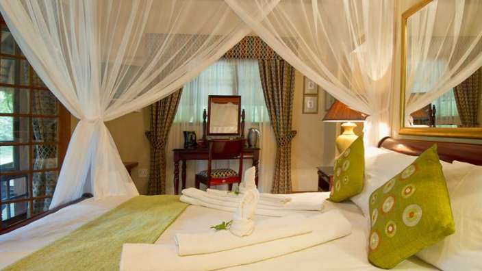 Ein Schlafzimmer mit einem Himmelbett und einem Spiegel