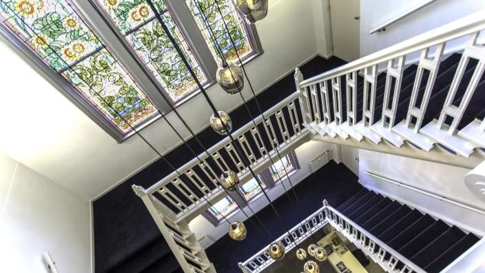 Eine Treppe mit einem Buntglasfenster im Hintergrund