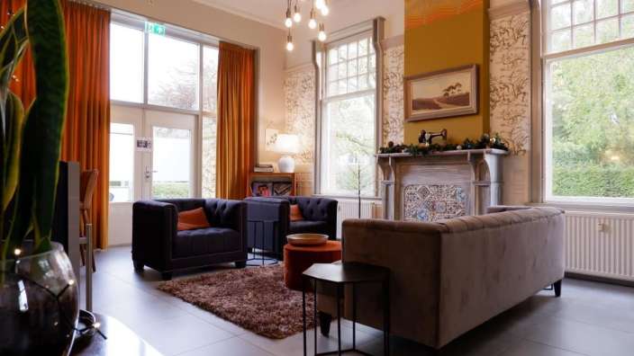 Ein Wohnzimmer mit einer Couch und zwei Stühlen