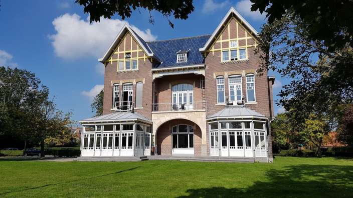 Ein großes Gebäude mit vielen Fenstern und einem blauen Dach