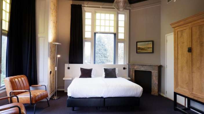 Ein Schlafzimmer mit einem Bett und zwei Stühlen