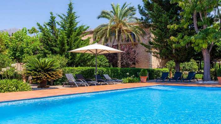 Ein großer Swimmingpool mit Liegestühlen und einem Sonnenschirm