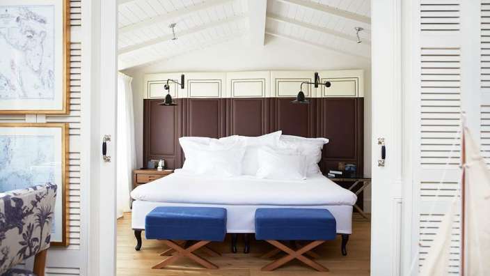 Ein Schlafzimmer mit einem Bett und blauen Hockern