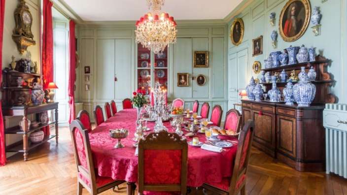 Ein Esszimmer mit einem Tisch und Stühlen und einem Kronleuchter