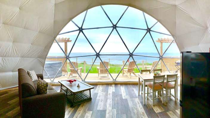 Ein Raum mit Möbeln und einem Fenster mit Blick auf das Meer