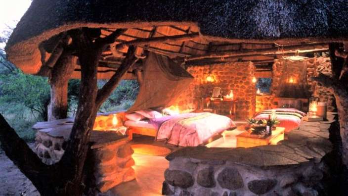 Ein Zimmer mit einem Bett und einem Kamin aus Steinen