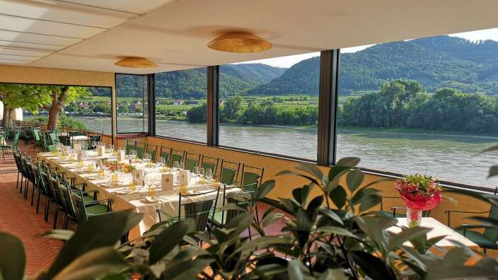 Tisch und Stühle in einem Restaurant mit Blick auf den Fluss