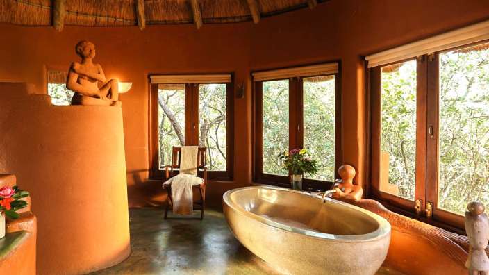 Ein Badezimmer mit einer Badewanne und vielen Fenstern