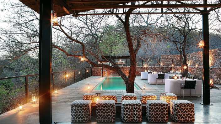 Eine Terrasse mit einem Swimmingpool und Stühlen