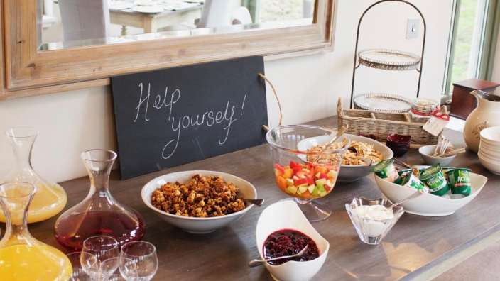 Ein Buffettisch mit einer Tafel mit der Aufschrift " help yourself " darauf