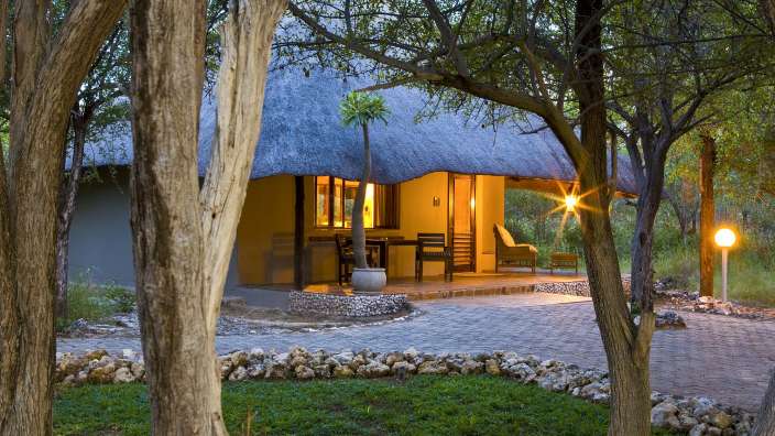 Ein Haus mit Strohdach inmitten eines Waldes