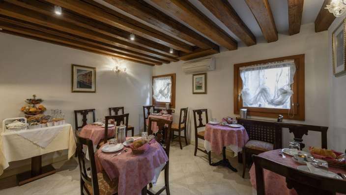 Ein Esszimmer mit Tischen und Stühlen und einem Buffet