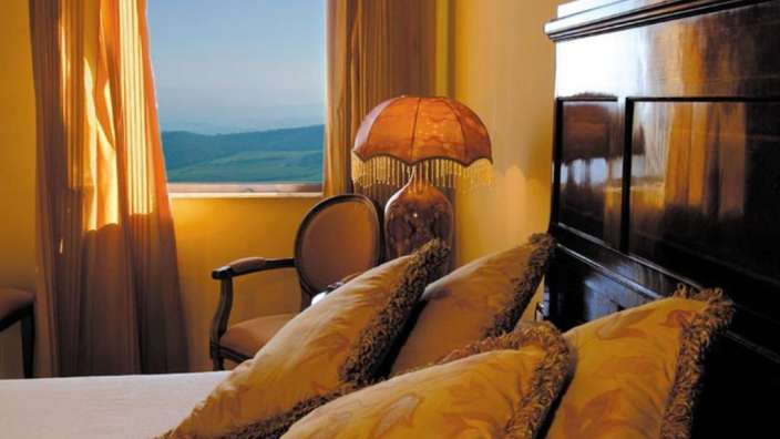 Ein Schlafzimmer mit einem Bett, einem Stuhl und einer Lampe