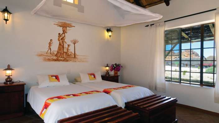 Ein Schlafzimmer mit zwei Betten und einem Gemälde an der Wand