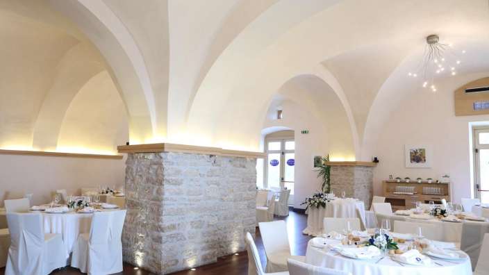 Ein Esszimmer mit weißen Tischen und Stühlen