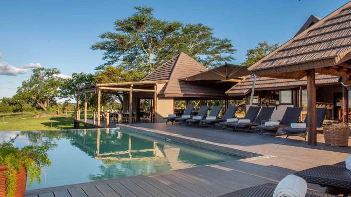 Ein großer Pool mit Liegestühlen und Sonnenschirmen um ihn