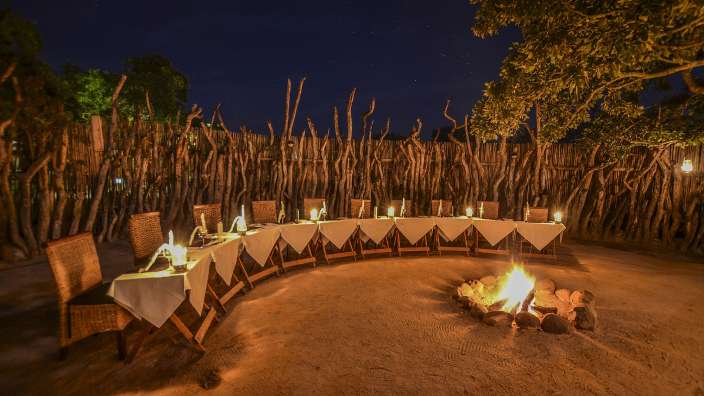 Ein Tisch und Stühle stehen rund um ein Feuer