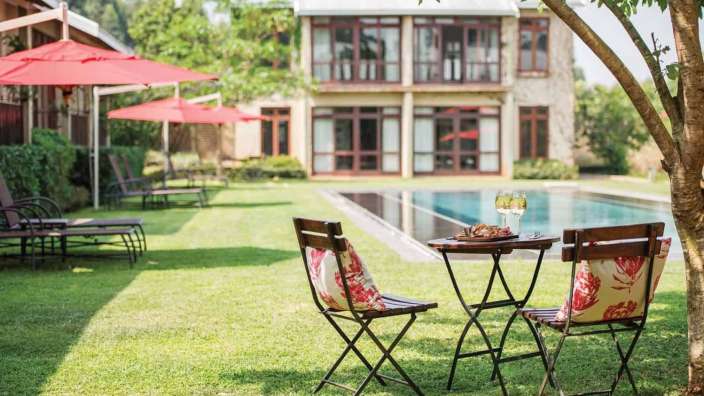 Ein Tisch und Stühle stehen vor einem großen Haus