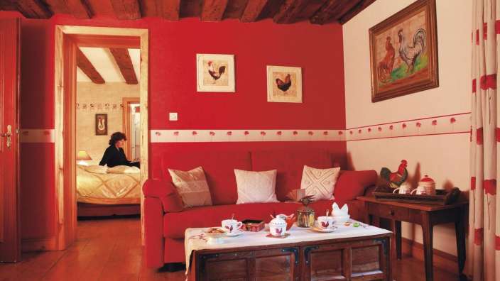 Eine Frau sitzt auf einer roten Couch in einem Wohnzimmer