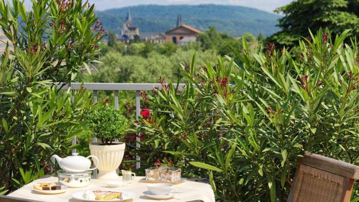 Ein Tisch mit einer Teekanne und Tassen auf einem Balkon