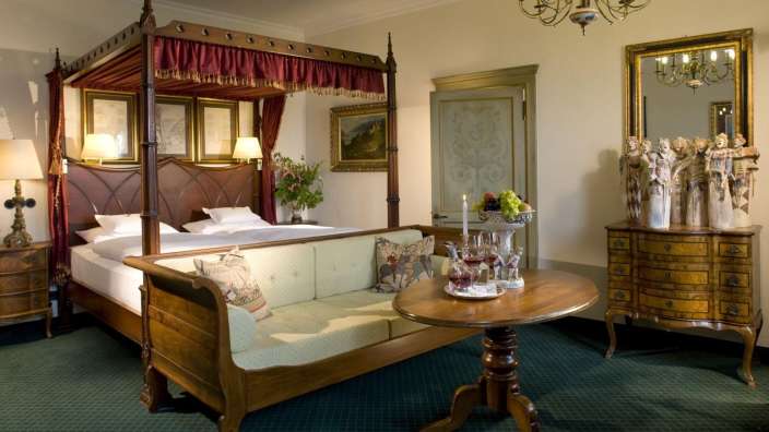 Ein Schlafzimmer mit einem Himmelbett und einem Couchtisch