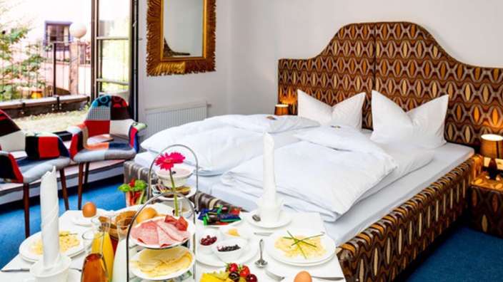 Ein Schlafzimmer mit zwei Betten und einem Tisch mit Essen darauf