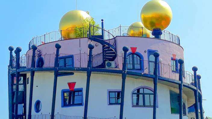 Ein rosa und weißes Gebäude mit goldenen Kugeln auf dem Dach