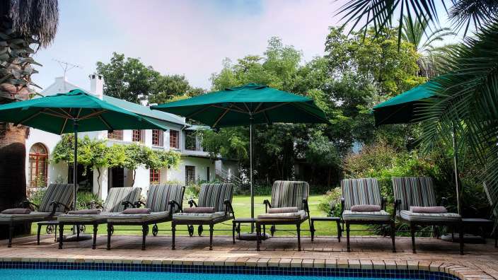 Eine Reihe von Stühlen und Sonnenschirmen um einen Swimmingpool