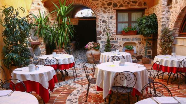 Tische und Stühle in einem Restaurant mit roten und weißen Tischdecken