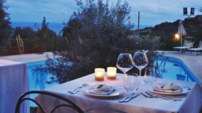 Ein Tisch mit Tellern und Gläsern in der Nähe eines Pools