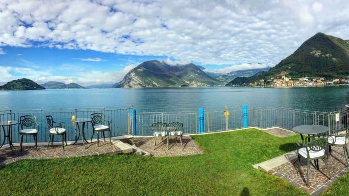 Tische und Stühle auf einem Balkon mit Blick auf einen See