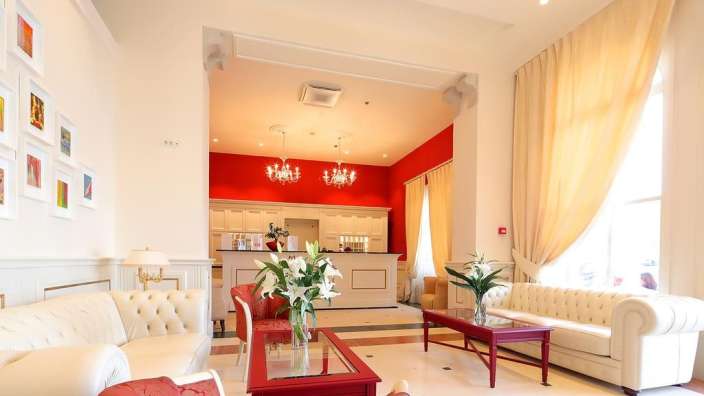 Ein Wohnzimmer mit weißen Möbeln und einem roten Tisch