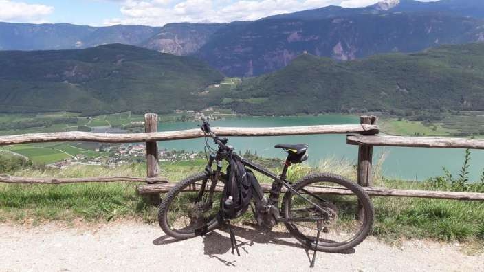 Ein Fahrrad sitzt neben einem Holzzaun mit einem See im Hintergrund