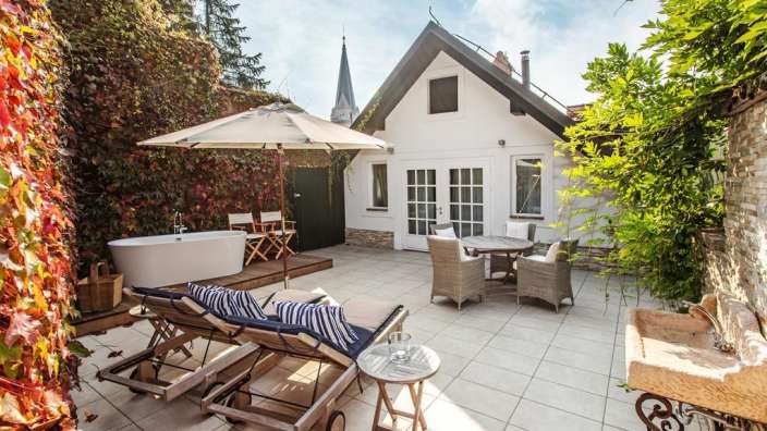 Eine Terrasse mit Liegestühlen und einer Badewanne