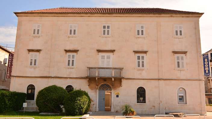 Ein großes Gebäude mit einem blauen Schild an der Seite , das sagt ' hotel '