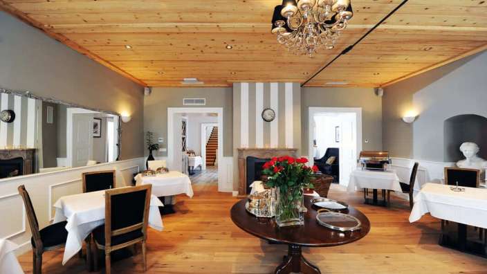 Ein Esszimmer mit Tisch und Stühlen und einem Kronleuchter