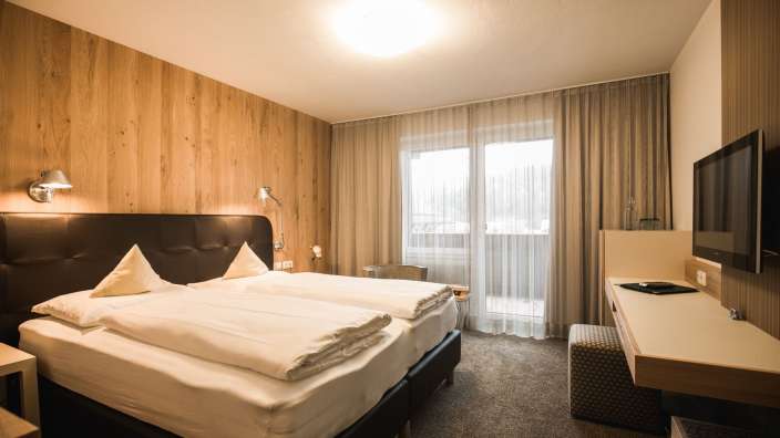 Ein Hotelzimmer mit zwei Betten und einem Fernseher