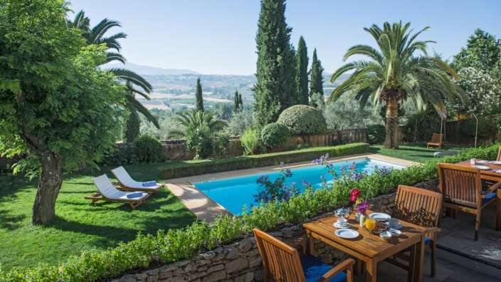 Ein Tisch und Stühle stehen neben einem Swimmingpool