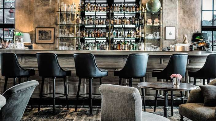 Eine Bar mit Stühlen und einem Tisch davor