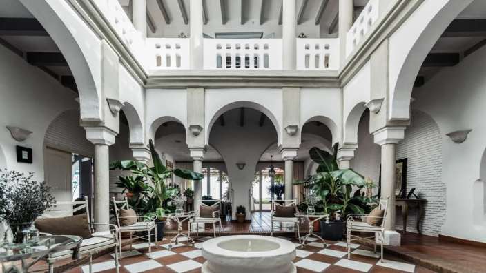 Ein großer Raum mit weißen Säulen und einem Schachbrettboden