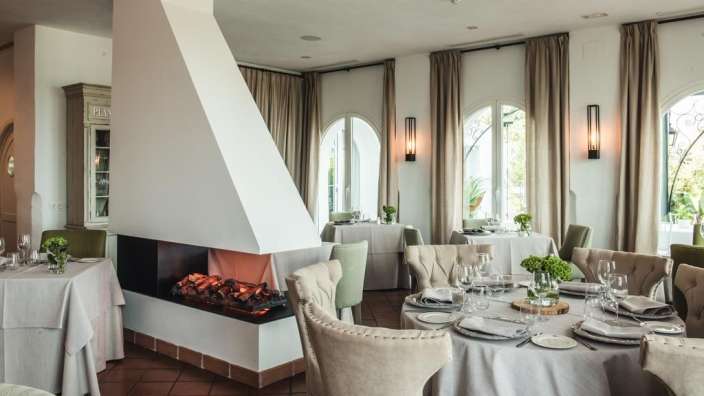 Ein Esszimmer mit Tischen und Stühlen und einem Kamin