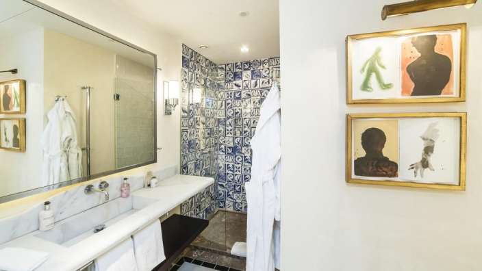 Ein Badezimmer mit Waschbecken und Dusche und Bildern an der Wand